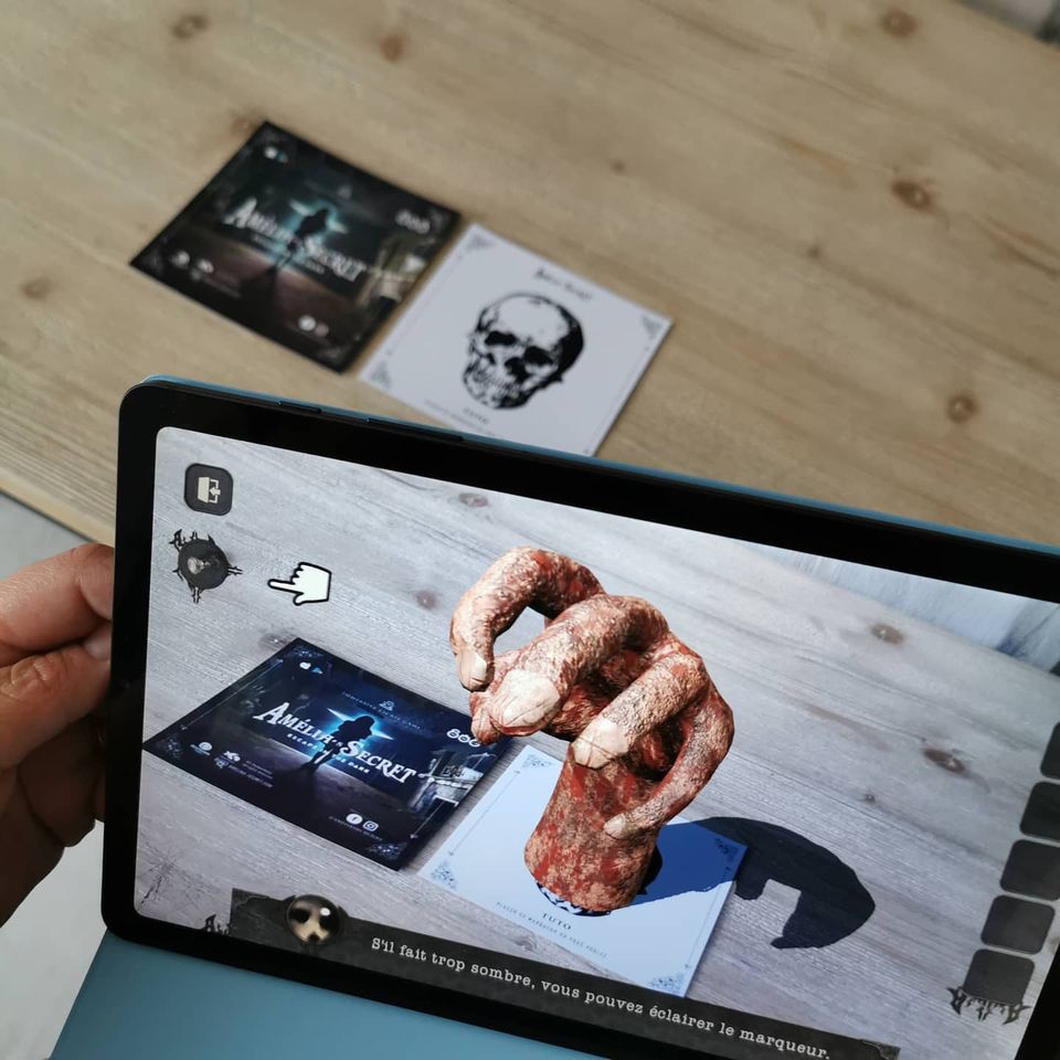Photo of a tablet scanning an AR marker and displaying 3D augmented content on it